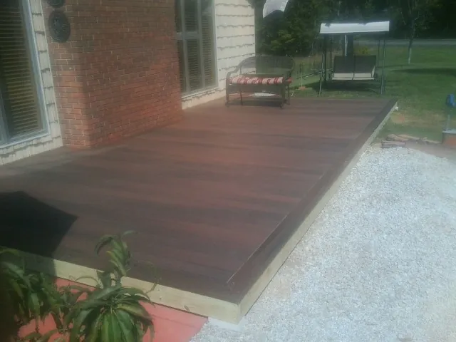 Freshly stained wood deck built against a brick home in Garden City