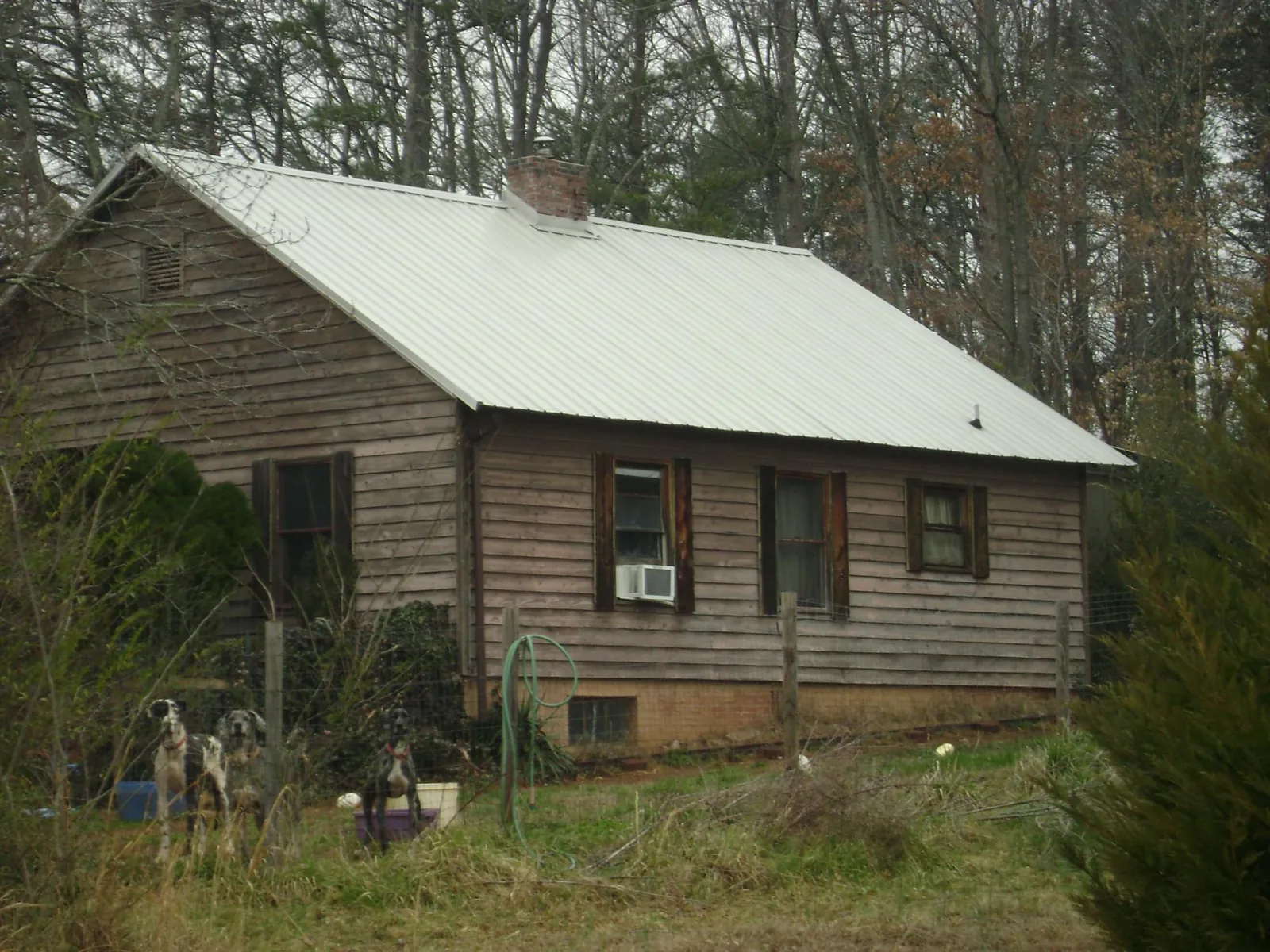 White metal roof on an old wood sided farmhouse, from a Metal Roof Installation job in Garden City